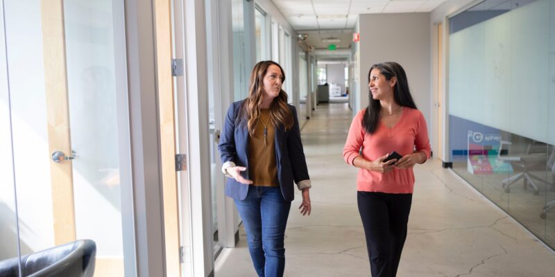 Two female co-workers taking a walking break to reduce stress at work.